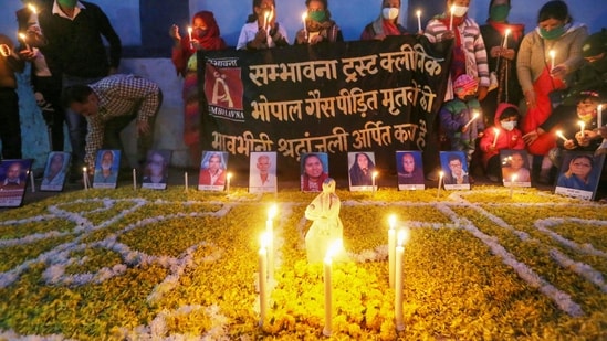 Members of Sambhavana Trust Clinic, which provides medical assistance to gas affected people, light candles to pay tribute to the victims of the 1984 gas tragedy on its 37th anniversary, in front of an abandoned Union Carbide plant, in Bhopal.(PTI)
