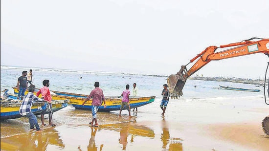 An earthmover is used to pull fishing boats ashore in view of the Cylone Jawad in Visakhapatnam on Friday. (PTI) An earthmover is used to pull fishing boats ashore in view of the Cylone Jawad in Visakhapatnam on Friday. (PTI)