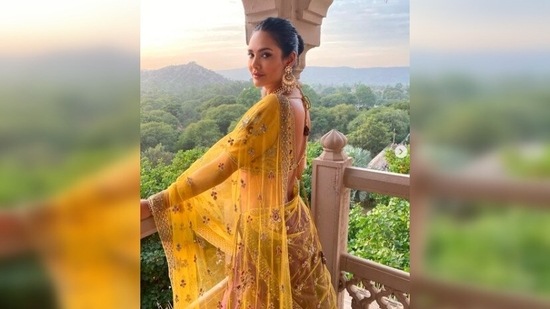 Esha Gupta's outfit featured intricate embroidery and sequins work, a plunging blouse neckline and a see-through yellow dupatta with gold netted borders.(Instagram/@egupta)