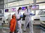 An Indian family dressed in personnel protective suits walk towards security gates after checking in their baggage at Kempegowda International Airport in Bengaluru, India.(AP) An Indian family dressed in personnel protective suits walk towards security gates after checking in their baggage at Kempegowda International Airport in Bengaluru, India.(AP)