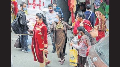 A policewoman takes people who were not wearing a mask, for random Covid testing, at a market in Jammu on Saturday. The Vaishno Devi shrine board is sanitising its premises in sync with the Covid guidelines and protocols. (PTI Photo)