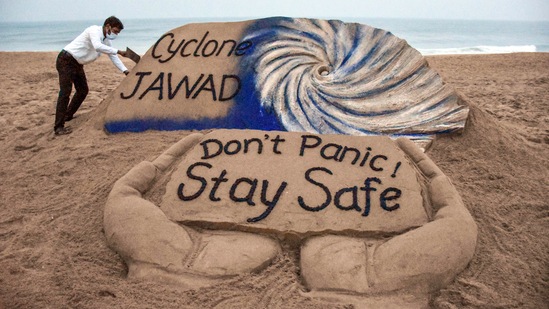 Puri artist Sudarshan Pattanaik gives finishing touches to a sand sculpture to create awareness on Cyclone Jawad. (PTI)