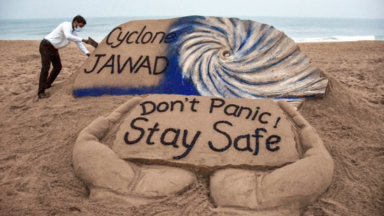 Puri artist Sudarshan Pattanaik gives finishing touches to a sand sculpture to create awareness on cyclone Jawad.&nbsp;(PTI)