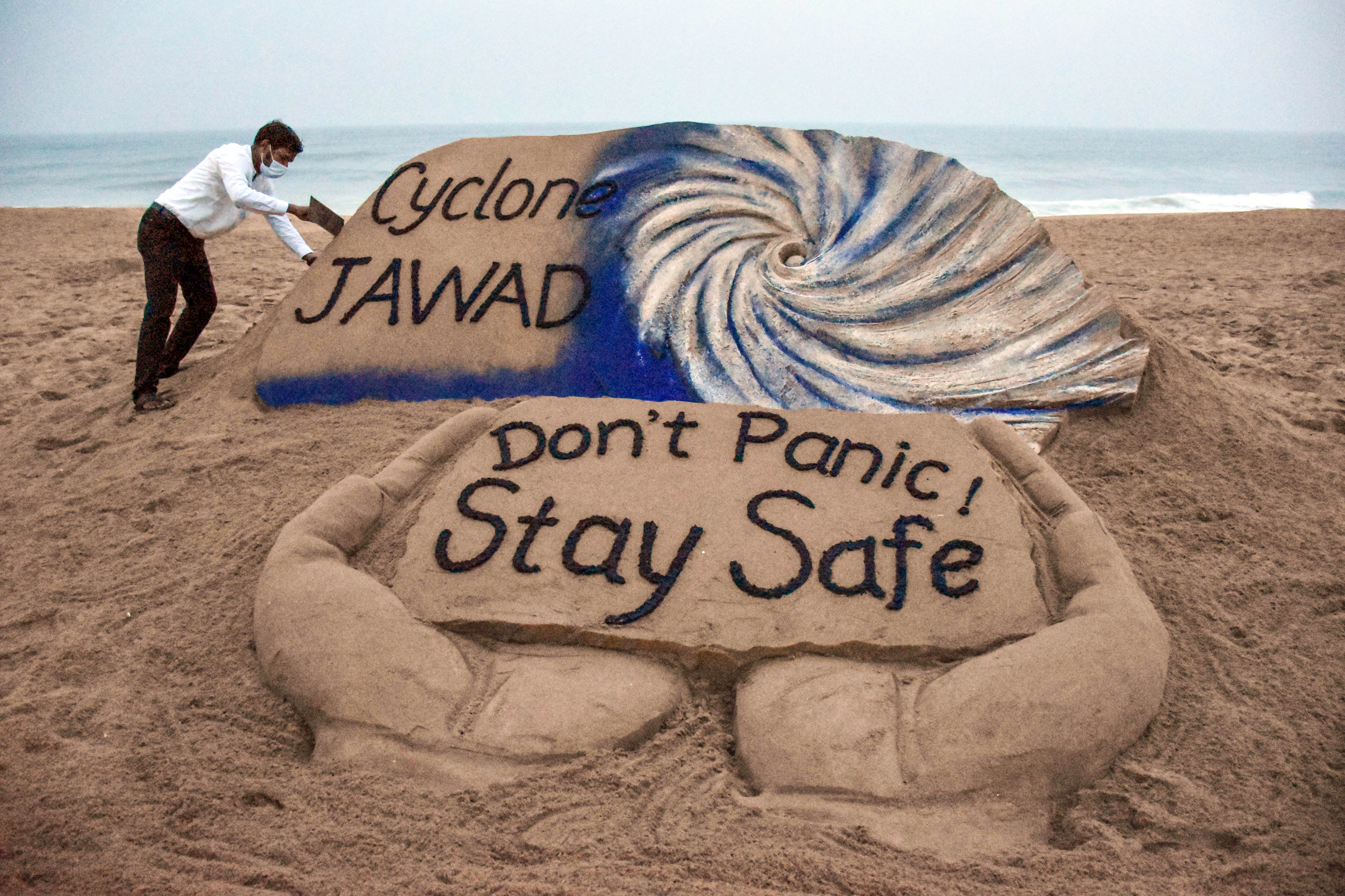 Puri artist Sudarshan Pattanaik gives finishing touches to a sand sculpture to create awareness on cyclone Jawad. (PTI) Puri artist Sudarshan Pattanaik gives finishing touches to a sand sculpture to create awareness on cyclone Jawad. (PTI)
