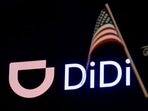 An American flag is pictured in front of the logo for Chinese ride hailing company Didi Global Inc. during the IPO on the New York Stock Exchange (NYSE) floor in New York City, US.