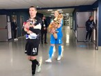 Players from Russian football club, Zenit, walk into the field holding a few dogs from a shelter looking to get adopted.(twitter/@fczenit_en)