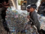 Workers push a bundle of crushed plastic bottles at a recycling factory in Ahmedabad, India.(REUTERS File)