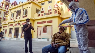 A healthcare worker collects a swab sample of a man for the Covid-19 test at Birla Mandir amid the threat of new Covid-19 variant Omicron, in New Delhi. (HT Photo)