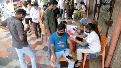People wait to receive a dose of the Covid-19 vaccine amid concern over the Omicron variant, in Navi Mumbai. (PTI) People wait to receive a dose of the Covid-19 vaccine amid concern over the Omicron variant, in Navi Mumbai. (PTI)