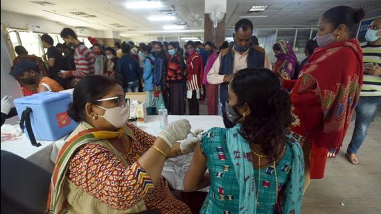A woman gets a dose of a Covid-19 vaccine at the District Hospital in Noida Sector 30 on Sunday. (Sunil Ghosh/HT)