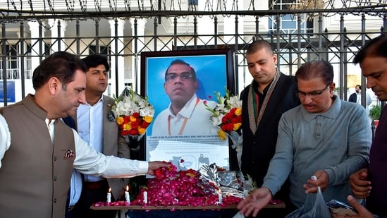 Businessmen put candles and rose petals next to the portrait of a Sri Lankan manager of a sports equipment factory, as they pay tribute to him outside the office of Sialkot Chamber of Commerce and Industry in Sialkot, Pakistan(AP Photo)