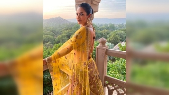 Esha Gupta's outfit featured intricate embroidery and sequins work, a plunging blouse neckline and a see-through yellow dupatta with gold netted borders.(Instagram/@egupta)