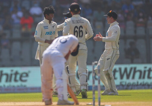New Zealand's Rachin Ravindra, left, celebrates the dismissal of India's Virat Kohli with his team players during the day three of their second test cricket match with India in Mumbai, India, Sunday, Dec. 5, 2021. (AP)