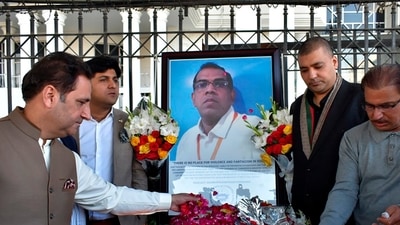 Businessmen put candles and rose petals next to the portrait of a Sri Lankan manager of a sports equipment factory, as they pay tribute to him outside the office of Sialkot Chamber of Commerce and Industry in Sialkot, Pakistan