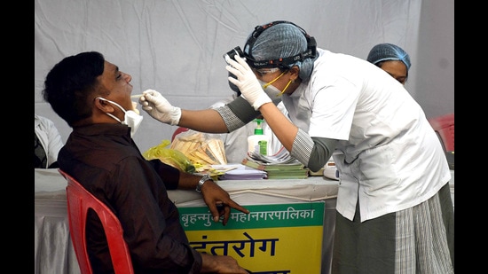 A healthcare worker collects a swab sample of a man for Covid-19 testing in wake of the new variant Omicron, at Veer Savarkar Road, in Mumbai on Monday. (ANI)