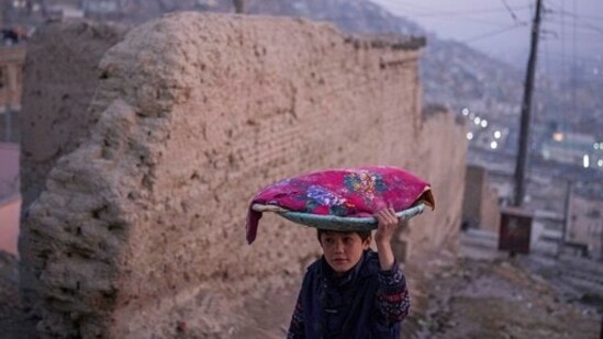 An Afghan boy carries a tray of bread on his head, in Kabul, Afghanistan.(AP)