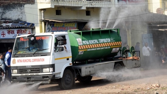 Patna Municipal Corporation workers spray disinfectant in a residential area amid Omicron threat, on Sunday.(PTI Photo)