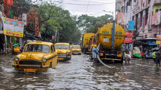 Kolkata Municipal Corporation (KMC) workers clear a water logged road after heavy rainfall due to Cyclone Jawad, in Kolkata on Monday, December 6, 2021. (PTI Photo)