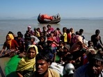Rohingya refugees sit on a makeshift boat as they get interrogated by the Border Guard Bangladesh after crossing the Bangladesh-Myanmar border, at Shah Porir Dwip near Cox's Bazar