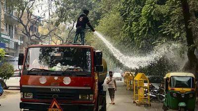 A municipal worker sprays water on roadside trees as part of efforts to reduce air pollution in New Delhi. (AP/File)