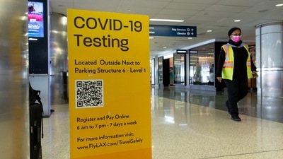 A sign informs travelers of a Covid-19 testing location at Los Angeles International Airport (LAX) in Los Angeles. T (Bloomberg) A sign informs travelers of a Covid-19 testing location at Los Angeles International Airport (LAX) in Los Angeles. T (Bloomberg)