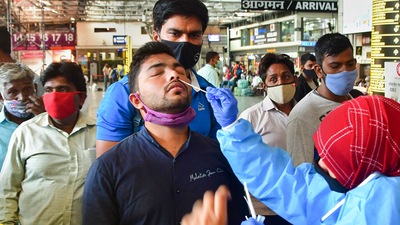 A health worker collects swab samples of a passenger for Covid-19 test at a CSMT railway station in Mumbai. (PTI/File Photo) A health worker collects swab samples of a passenger for Covid-19 test at a CSMT railway station in Mumbai. (PTI/File Photo)