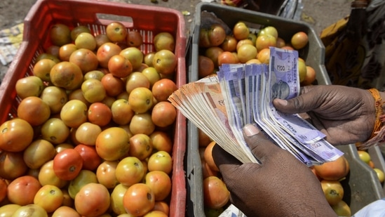 A trader counts money at a vegetable wholesale market in Hyderabad(AFP)