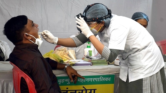 A healthcare worker collects a swab sample of a man for Covid-19 test in wake of the new variant Omicron, in Mumbai on Monday.(ANI Photo)