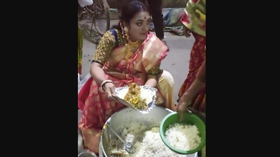 The image of the woman distributing leftover food from brother's wedding was shared on Instagram. (Instagram/@ig_calcutta)