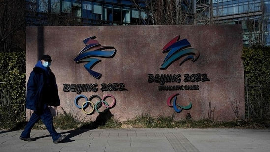 A man walks past the logos of the Beijing 2022 Winter Olympics and Paralympic Winter Games in Shougang Park, one of the sites for the Beijing 2022 Winter Olympics, in Beijing. (AFP)