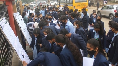 Students look for their roll numbers in the seat allocation sheet before taking the CBSE 12th English Board Exams 2022 for Term 1 in Gurugram on Dec. 3, 2021. (PTI)