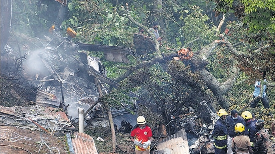 Rescuers stand near the debris of the Russian-made Mi-17V5 helicopter after it crashed near the Coonoor, on Thursday. (REUTERS)