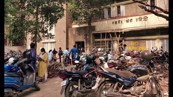 People are seen waiting outside the property registration office on Thursday. (Rahul Raut/HT PHOTO)