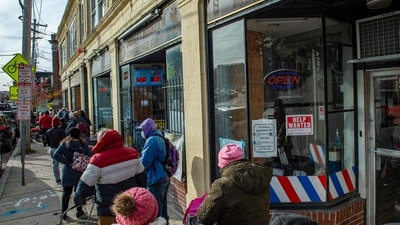 Hundreds of people wait in a line that stretched several blocks from the pantry for their turn to receive food at the La Colaborativa Food Pantry in Chelsea, Massachusetts (AFP)