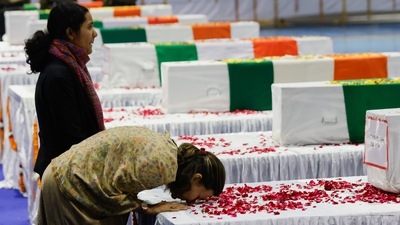 Wife and daughter of Brigadier LS Lidder, an Indian army officer who died in a helicopter crash, pay homage next to the coffin containing his mortal remains during a wreath laying ceremony in New Delhi. (Reuters)