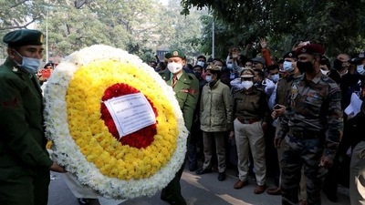 Soldiers carry a wreath outside the residence of chief of defence staff General Bipin Rawat, who died in a helicopter crash, as people pay respects to the general and his wife Madhulika Rawat in New Delhi. (Reuters)