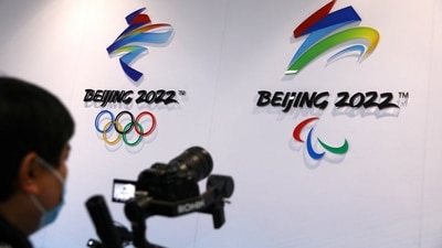 A reporter films logos of Beijing 2022 Winter Olympics at an exhibition room (REUTERS)