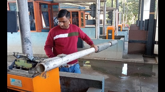 After farmers left the site, preparations underway to reopen the Himalayan Expressway Toll Plaza in Chandimandir. Chandigarh MC is to go to the polls on December 24. (SANT ARORA/HT)