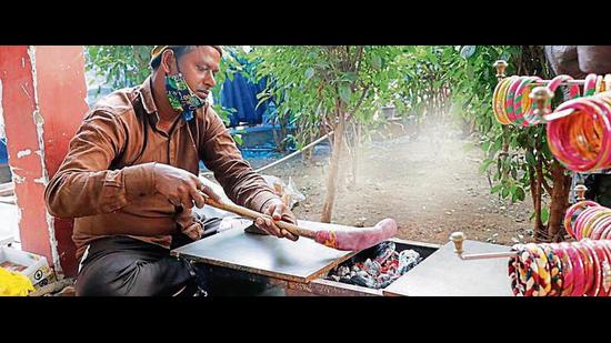 An artisan demonstrates the preparation of lac bangles at the fair. (Photos: Dhruv Sethi/HT )
