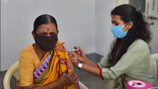 A health worker administers a dose of Covid-19 vaccine to a beneficiary at a government hospital amid fear of spread of 'Omicron variant' in Bengaluru on Friday. (PTI)