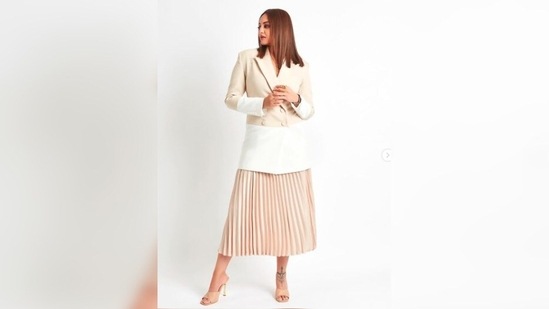 For the event, Sonakshi Sinha opted for a beige and white long blazer which she teamed with a beige pleated skirt.(Instagram/@aslisona)