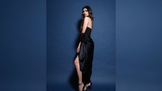Mouni Roy raises the hotness quotient in a strapless black corset and a thigh-high slit wrap-around skirt.(Instagram/@imouniroy)