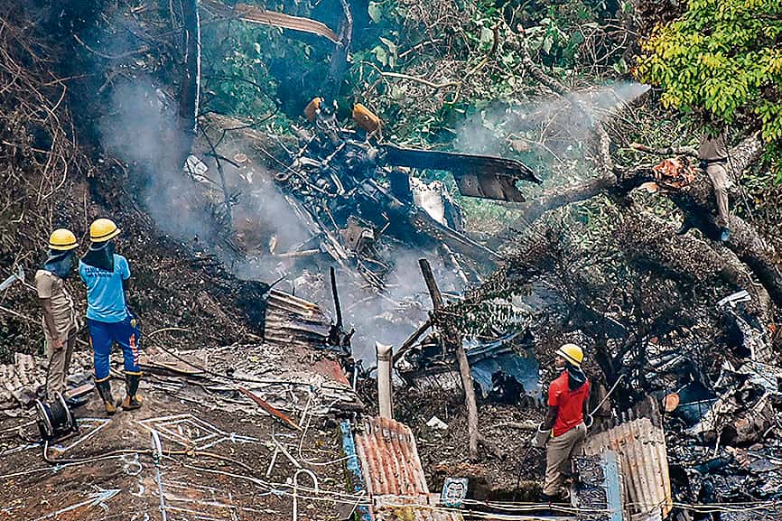 Firemen and rescue workers stand next to the debris of an IAF Mi-17V5 helicopter crash site in Coonoor, Tamil Nadu, on December 8, 2021 (AFP) Firemen and rescue workers stand next to the debris of an IAF Mi-17V5 helicopter crash site in Coonoor, Tamil Nadu, on December 8, 2021 (AFP)