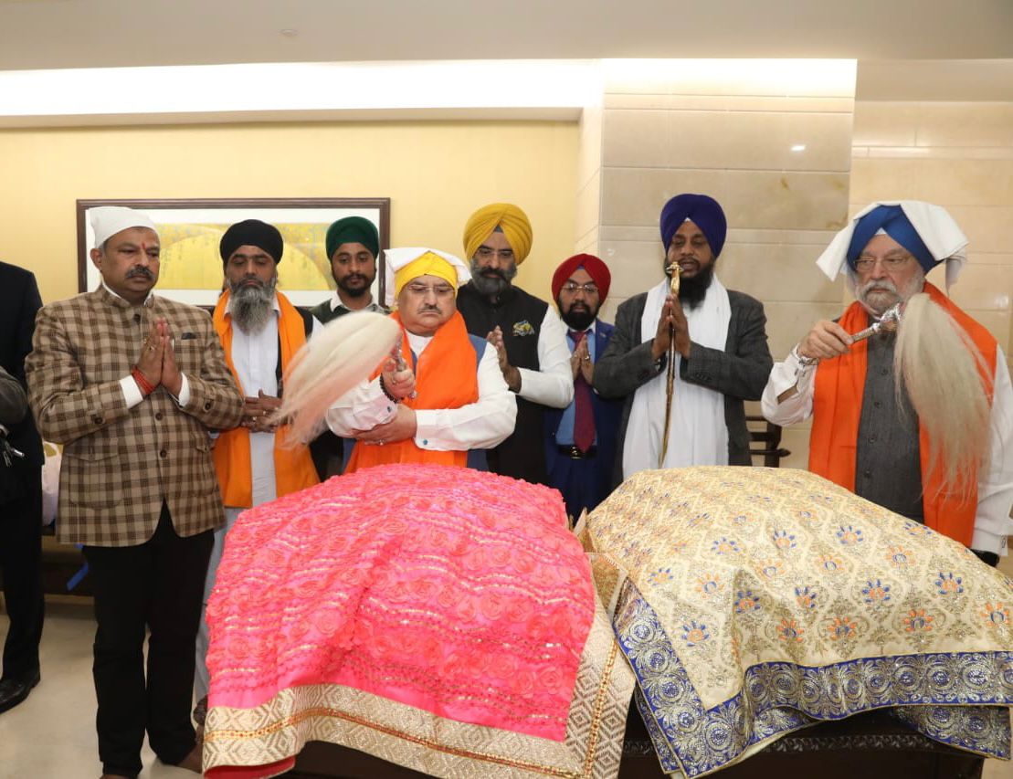 Union minister Hardeep Singh Puri and BJP chief JP Nadda carried the Guru Granth Sahibs which were brought back from Afghanistan. (SOURCED) Union minister Hardeep Singh Puri and BJP chief JP Nadda carried the Guru Granth Sahibs which were brought back from Afghanistan. (SOURCED)