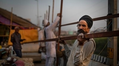 Indian farmers dismantle temporary structures used during protests in Ghazipur, outskirts of New Delhi. (AP)
