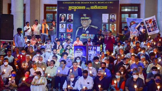 People hold candles as they pay tribute to late Chief of Defense Staff (CDS) General Bipin Rawat in Bengaluru on Saturday. (PTI)