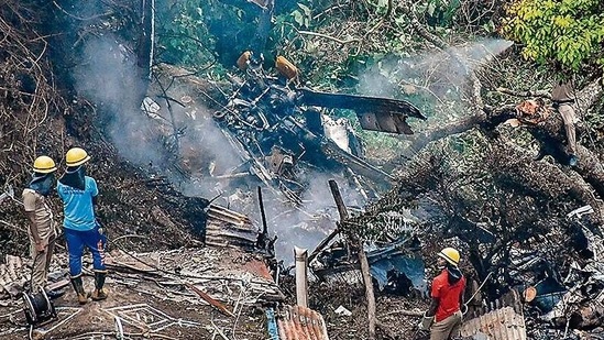 Firemen and rescue workers stand next to the debris of an IAF Mi-17V5 helicopter crash site in Coonoor,&nbsp;(AFP File Photo)