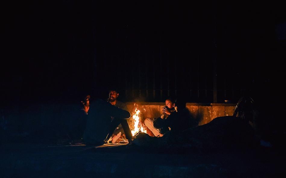 People warm themselves around a bonfire on a cold winter evening at NIzamuddin in New Delhi. ((Photo by Amal KS / Hindustan Times)) People warm themselves around a bonfire on a cold winter evening at NIzamuddin in New Delhi. ((Photo by Amal KS / Hindustan Times))