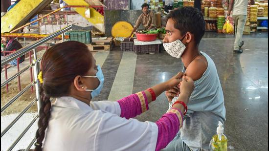 A health worker administers a dose of Covid-19 vaccine to a beneficiary at K R Market, amid a possible threat of the spread of Omicron variant of COVID-19, in Bengaluru. (PTI PHOTO.) A health worker administers a dose of Covid-19 vaccine to a beneficiary at K R Market, amid a possible threat of the spread of Omicron variant of COVID-19, in Bengaluru. (PTI PHOTO.)
