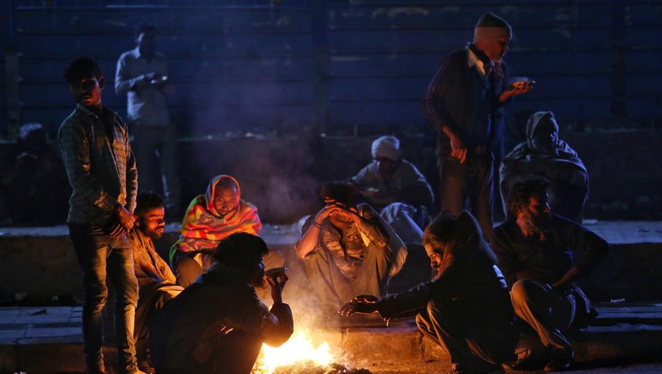 People next to a bonfire on a cold evening at Kashmere Gate, on Sunday when the mercury dipped to 6.4 degrees Celsius -- the season’s lowest so far. (Sanchit Khanna/HT Photo) People next to a bonfire on a cold evening at Kashmere Gate, on Sunday when the mercury dipped to 6.4 degrees Celsius -- the season’s lowest so far. (Sanchit Khanna/HT Photo)
